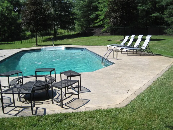 backyard with a custom designed stamped concrete swimming pool deck.