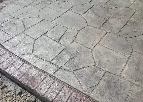 Stamped Concrete with a darker edge that looks like bricks.